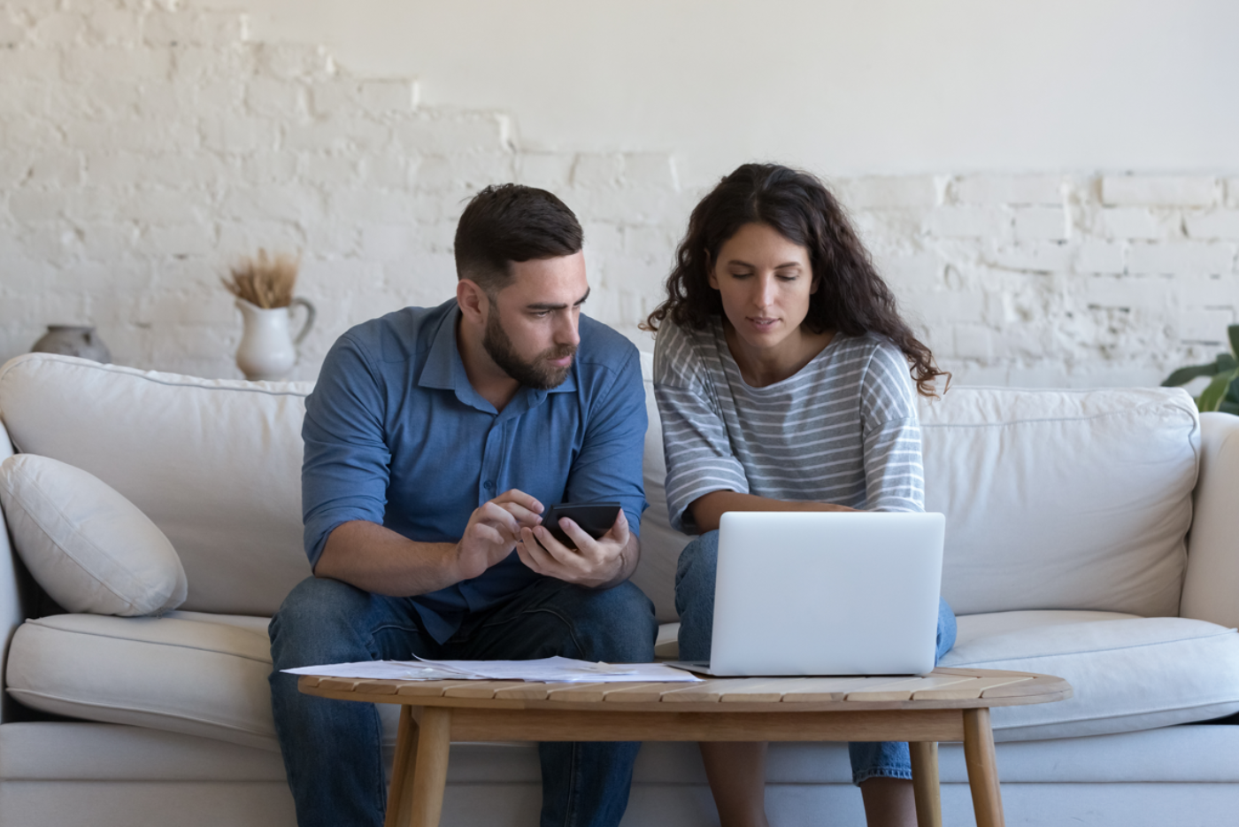 Couple qui regarde les factures avec une calculatrice en mains